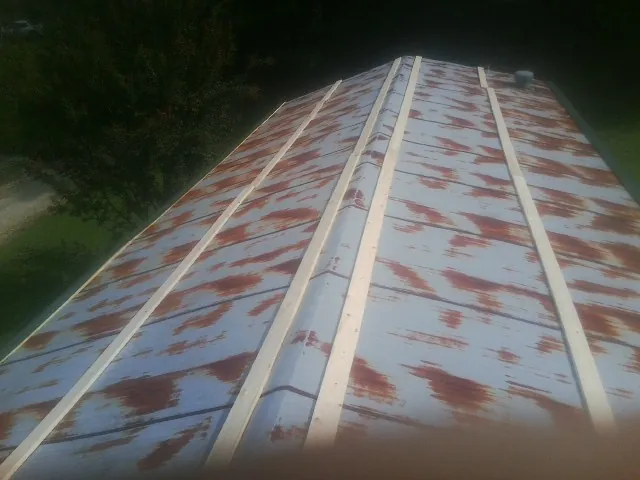 Rusted metal roof panels with new wood purlins before replacement — Storm Damage Roof Repair in Silver Lake by Roofing Brothers